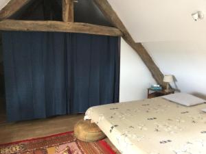 a bedroom with a bed and a blue curtain at Nuitées au calme de la campagne bourbonnaise in Paray-sous-Brailles