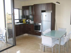 a kitchen with a table and chairs and a refrigerator at Herzliya Pituach Apartment with Pool, by the Beach in Herzliya