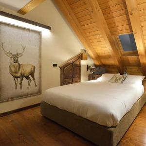 a bedroom with a large bed with a deer painting on the wall at L'Ame du Mont blanc vda.cir 0061 in Pré-Saint-Didier