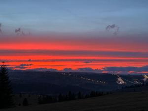 um pôr-do-sol numa colina com um céu vermelho em Przystań w Rzepiskach em Rzepiska