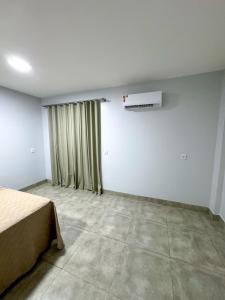 um quarto vazio com uma cama e uma janela em Rodotel Vênus Prime em Rio Verde