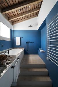 ein Badezimmer mit blauen Wänden und Treppen mit einer Badewanne in der Unterkunft Quinta Da Comporta - Wellness Boutique Resort in Comporta