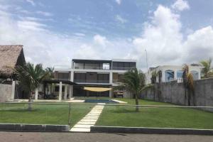 una casa grande con una pista de tenis enfrente en The House Of Hope, en La Muerte