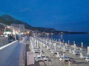 a row of chairs on a beach near the water at Apartmani Holiday Sutomore in Sutomore