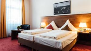 a hotel room with two beds and two lamps at Arcade Hotel in Wuppertal