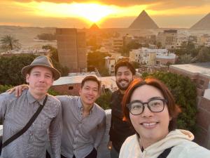 eine Gruppe von Menschen, die vor den Pyramiden stehen in der Unterkunft LOAY PYRAMIDS VIEW in Kairo