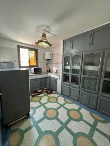 una cucina con armadi blu e un tappeto sul pavimento di DAR SANAE SURF ad Aourir