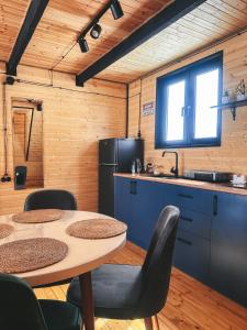 a kitchen with a table and two chairs and a refrigerator at Wildwood Kazbegi in Stepantsminda