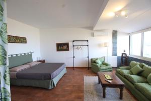 Villa Rosa Bianca في باليرمو: غرفة نوم بسرير واريكة وطاولة