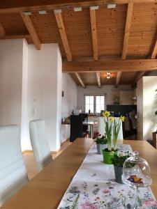 una sala da pranzo con tavolo e fiori di Ferienwohnung Mader a Kolsass