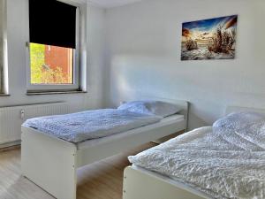 2 łóżka pojedyncze w pokoju z oknem w obiekcie Apartment mit Balkon in Marl w mieście Marl