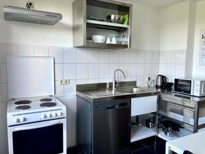kuchnia ze zlewem i kuchenką w obiekcie Apartment mit Balkon in Marl w mieście Marl
