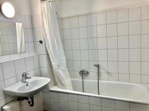 biała łazienka z umywalką i wanną w obiekcie Apartment mit Balkon in Marl w mieście Marl