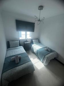 1 dormitorio con 2 camas y ventana en Apartamento San Eloy con plaza de garaje en Playa Honda