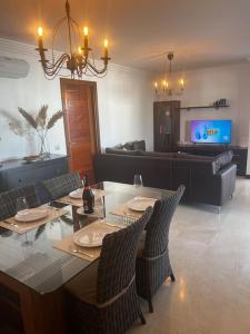 a dining room with a table and chairs and a television at Apartamento San Eloy con plaza de garaje in Playa Honda