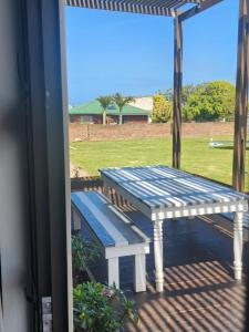 a picnic table and a bench on a porch at Atlantis Haven in Sunrise-on-Sea