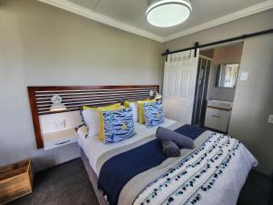 1 dormitorio con 1 cama grande con almohadas azules y amarillas en Atlantis Haven, en Sunrise-on-Sea