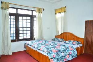 een slaapkamer met een bed en een raam bij Hotel John's Palace in Srinagar