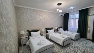 Habitación de hotel con 2 camas y 2 sofás en Royal Hotel en Navoi