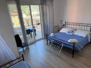 1 dormitorio con 1 cama y balcón con mesa y sillas en Affittacamere Il Veliero, en Levanto