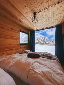 a large bed in a room with a window at Wildwood Kazbegi in Stepantsminda