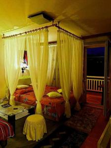 een slaapkamer met een hemelbed en witte gordijnen bij Apartmani GS ***** Zavidovici in Zavidovići