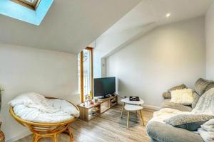 a living room with a couch and a tv at Duplex T3 Hypercentre 65m² in Voiron