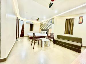 a living room with a couch and a table and chairs at Hotel Yashasvi ! Puri fully-air-conditioned-hotel near-sea-beach-&-temple with-lift-and-parking-facility breakfast-included in Puri