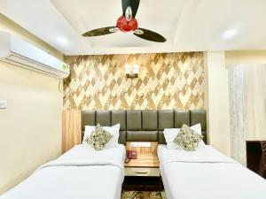 2 camas en una habitación con ventilador de techo en Hotel Yashasvi ! Puri fully-air-conditioned-hotel near-sea-beach-&-temple with-lift-and-parking-facility breakfast-included, en Puri
