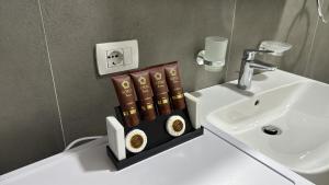 a bathroom sink with books on a counter next to a sink at SoleMar Suites in Vlorë +30 photos