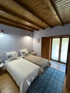 um quarto com 2 camas e uma grande janela em Quinta do Espigueiro em Celorico de Basto