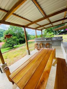 a wooden bench on a patio with a grill at Tabaco Lodge #2 a solo 5 minutos de Playa Carrillo in Carrillo