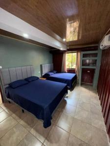 2 camas en un dormitorio con sábanas azules en Tabaco Lodge #2 a solo 5 minutos de Playa Carrillo en Carrillo