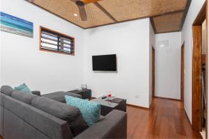 a living room with a couch and a flat screen tv at Atupa Suites in Avatiu
