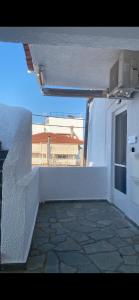 a balcony of a white building with a window at Vicky's house in Olympiada