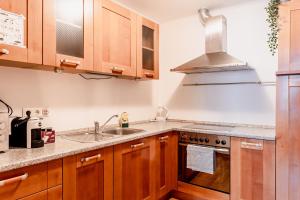 a kitchen with a sink and a stove at Town Hall Square Apartment with Sauna in Tallinn