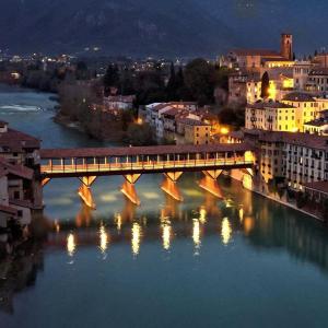 un ponte su un fiume in una città di notte di HEATHER'S HOME a Bassano del Grappa