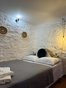 a bedroom with a bed with a stone wall at O Mylos in Ermoupoli +37 photos