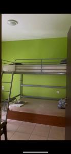 a room with two bunk beds and a green wall at Vicky's house in Olympiada