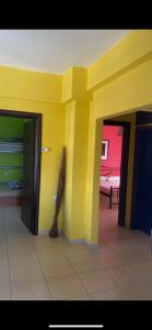 Pokój z dwoma drzwiami i żółtą ścianą w obiekcie Vicky's house w mieście Olympiada