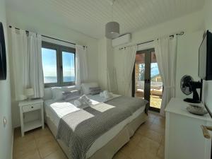 Habitación blanca con cama y balcón. en Horizon Villa Mani - Seaview Family Friendly House, en Stoupa