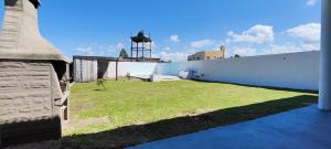 un gran patio con una pared blanca y césped en Casa de Campo "El Molino" en Federación