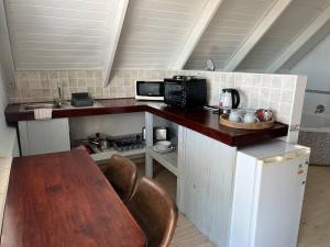 a small kitchen with a table and a microwave at Tranquility Betty's Bay in Sunny Seas