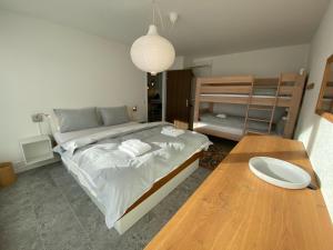 Schlafzimmer mit einem Bett und einem Holztisch in der Unterkunft Lorez 5E by Arosa Holiday in Arosa