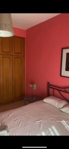 a bedroom with a red wall and a bed at Vicky's house in Olympiada