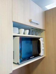 un four micro-ondes dans une armoire avec de la vaisselle dans l'établissement Paraíso de la Costa Brava, à Portbou