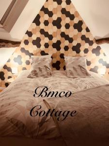 a bedroom with a large bed with a geometric headboard at Bmco cottage in Estrées-Saint-Denis