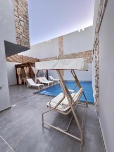 einen Stuhl, einen Tisch und einen Pool in der Unterkunft Luxury Villa Bali Al Gouna Hurgh in Hurghada