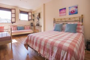 a bedroom with a bed with a checkered blanket at Atico-Terraza Imperial in Toledo