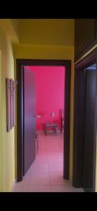 an open door to a room with a pink wall at Vicky's house in Olympiada